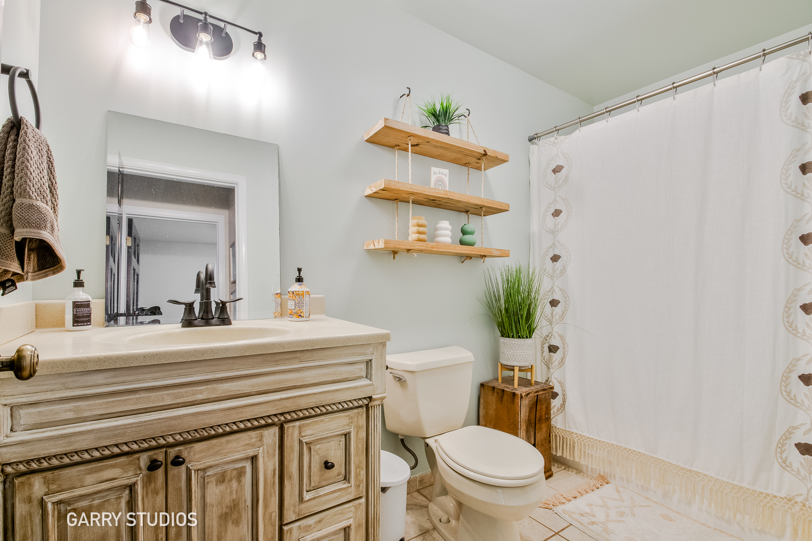28824 Rivers Edge Drive Cary, IL 60013 - Photo 16 of 39 a bathroom with a sink a toilet a mirror and shower curtain