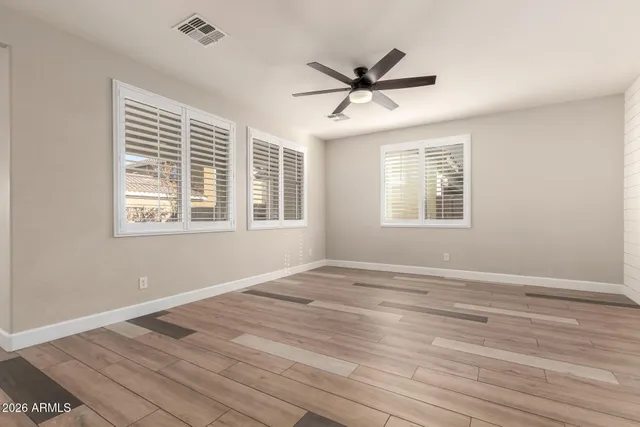 a view of a big room with wooden floor and windows