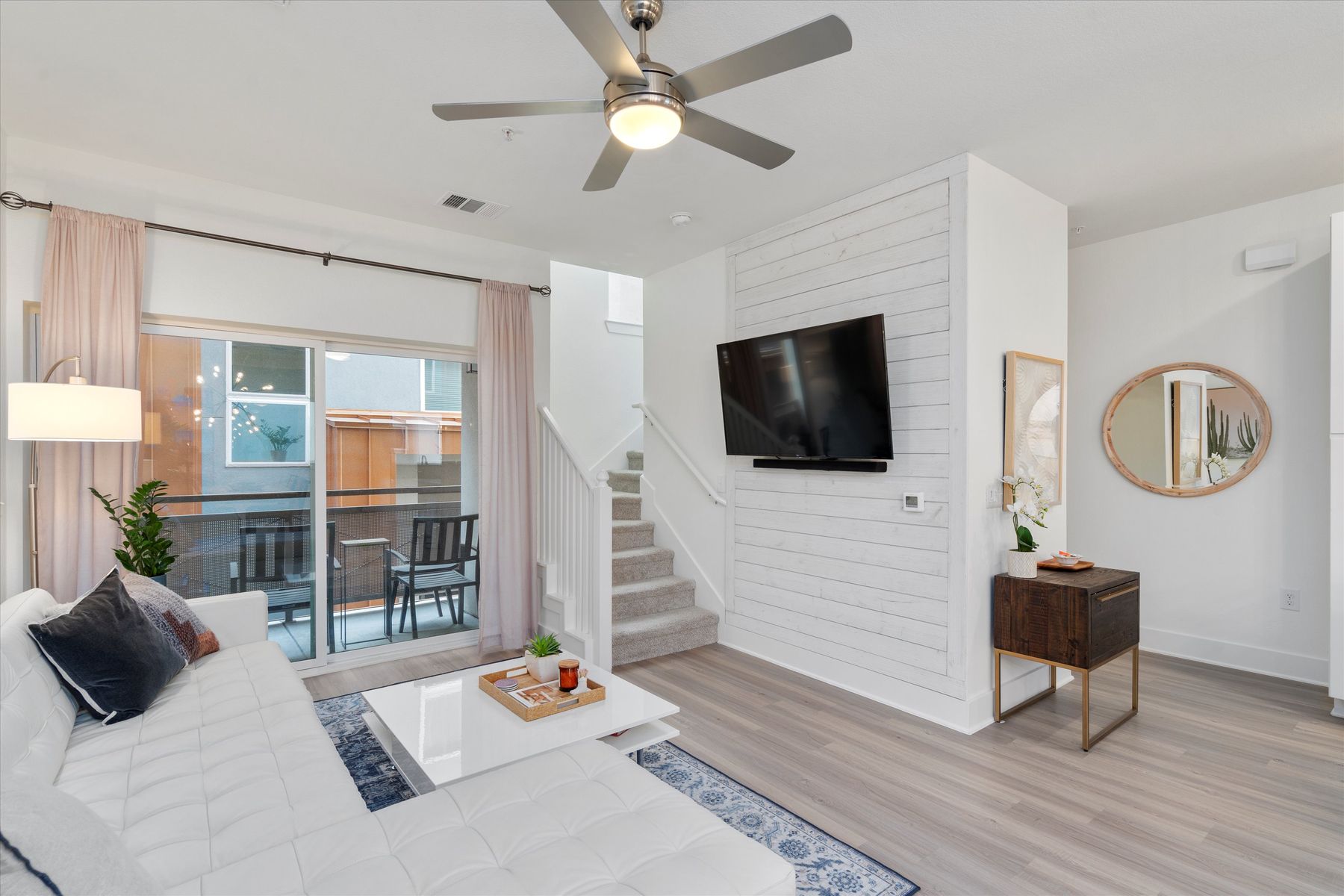 2827 Manor Road, Unit 3102 Austin, TX 78722 - Photo 3 of 18 Well-lit living space with a ceiling fan, plank flooring, and a private balcony for relaxation.