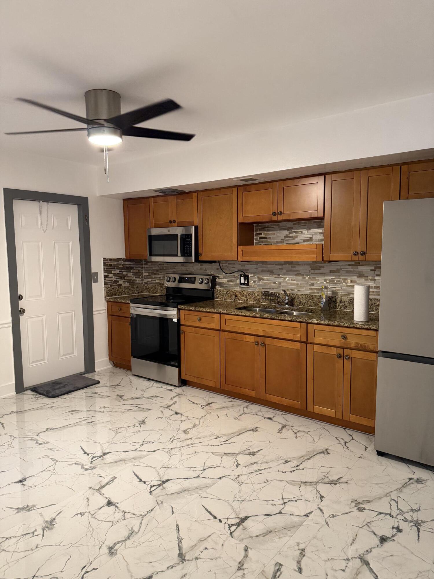 415 Southwest 8th Street Hallandale Beach, FL 33009 - Photo 2 of 10 a kitchen with stainless steel appliances granite countertop a stove a sink and a refrigerator