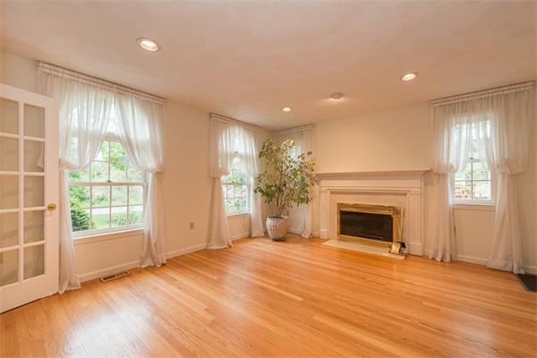 4 Farm Road Lexington, MA 02420 - Photo 3 of 28 an empty room with wooden floor fireplace and windows