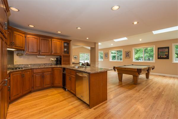4 Farm Road Lexington, MA 02420 - Photo 10 of 28 a kitchen with stainless steel appliances granite countertop a stove top oven a sink dishwasher a dining table and chairs with wooden floor