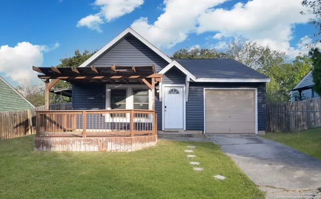 a view of a house with a small yard and wooden fence