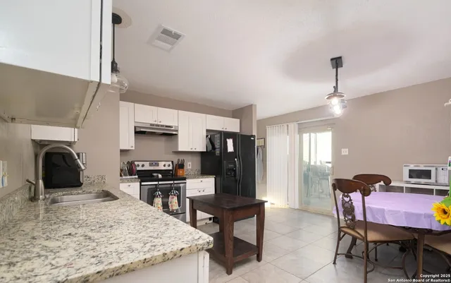 a kitchen with stainless steel appliances granite countertop a stove top oven a sink dishwasher and a refrigerator with wooden floor