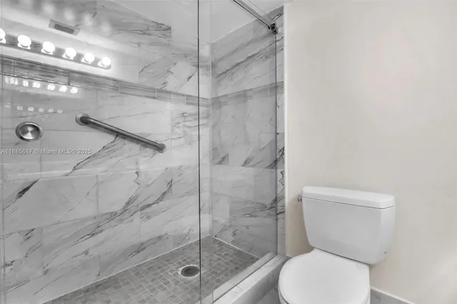 a bathroom with a granite countertop toilet sink and mirror