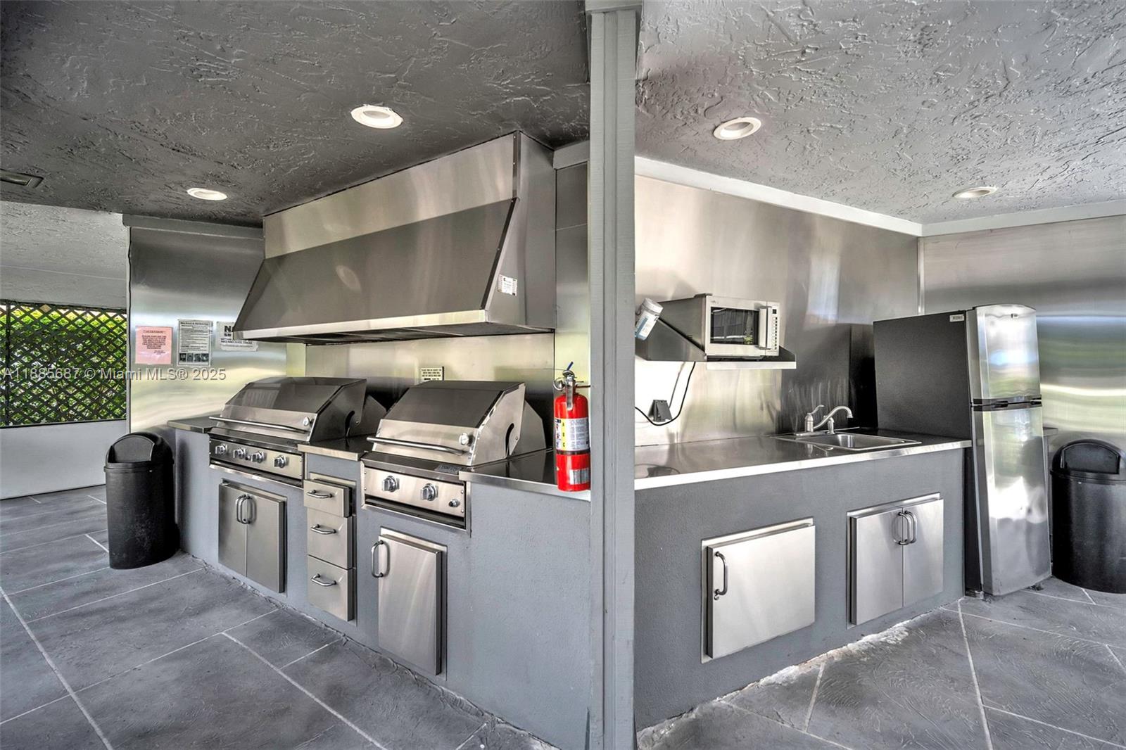 150 South Hollybrook Terrace, Unit 101 Pembroke Pines, FL 33025 - Photo 27 of 31 a kitchen with stainless steel appliances granite countertop a stove and a refrigerator
