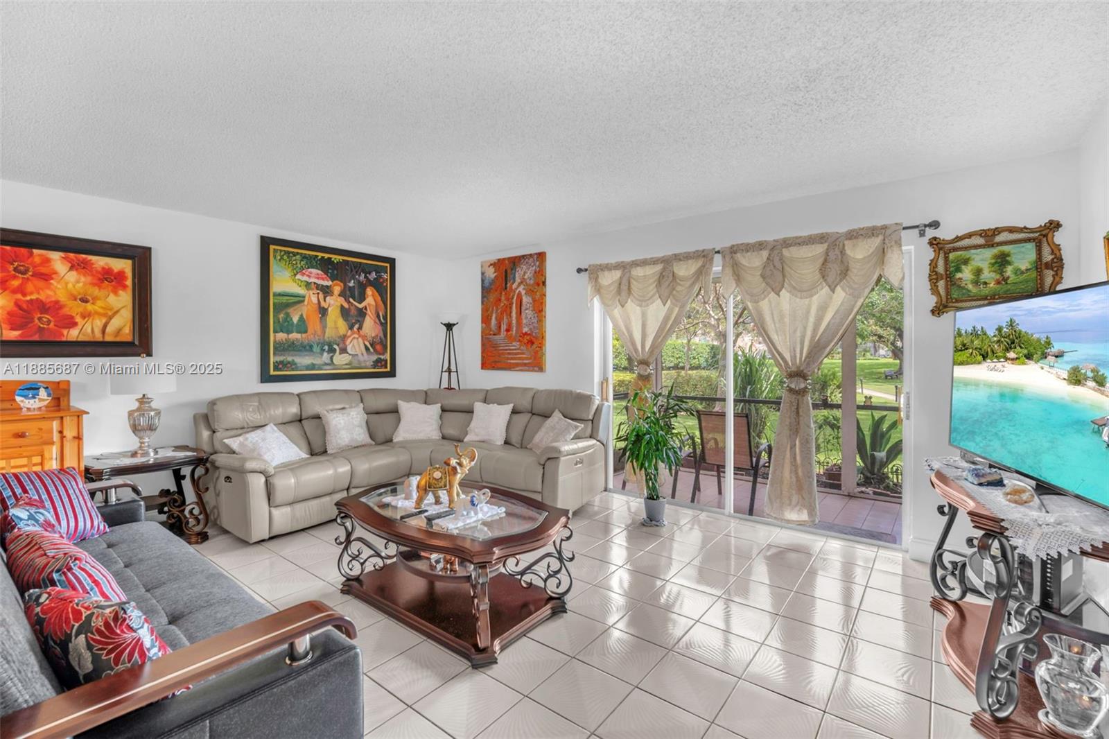 150 South Hollybrook Terrace, Unit 101 Pembroke Pines, FL 33025 - Photo 3 of 31 a living room with furniture a flat screen tv and a floor to ceiling window