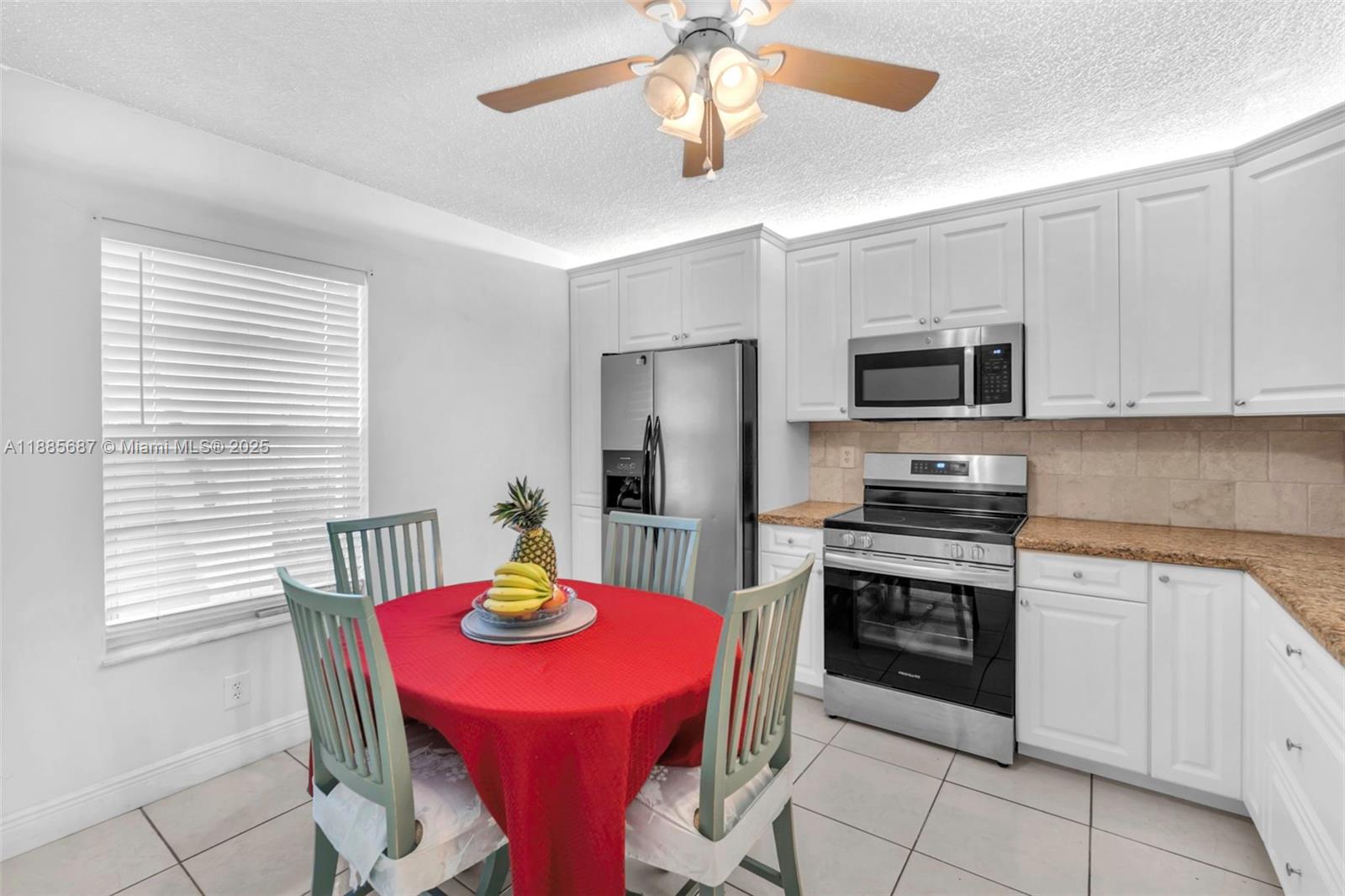 150 South Hollybrook Terrace, Unit 101 Pembroke Pines, FL 33025 - Photo 7 of 31 a kitchen with stainless steel appliances granite countertop a dining table chairs microwave and sink