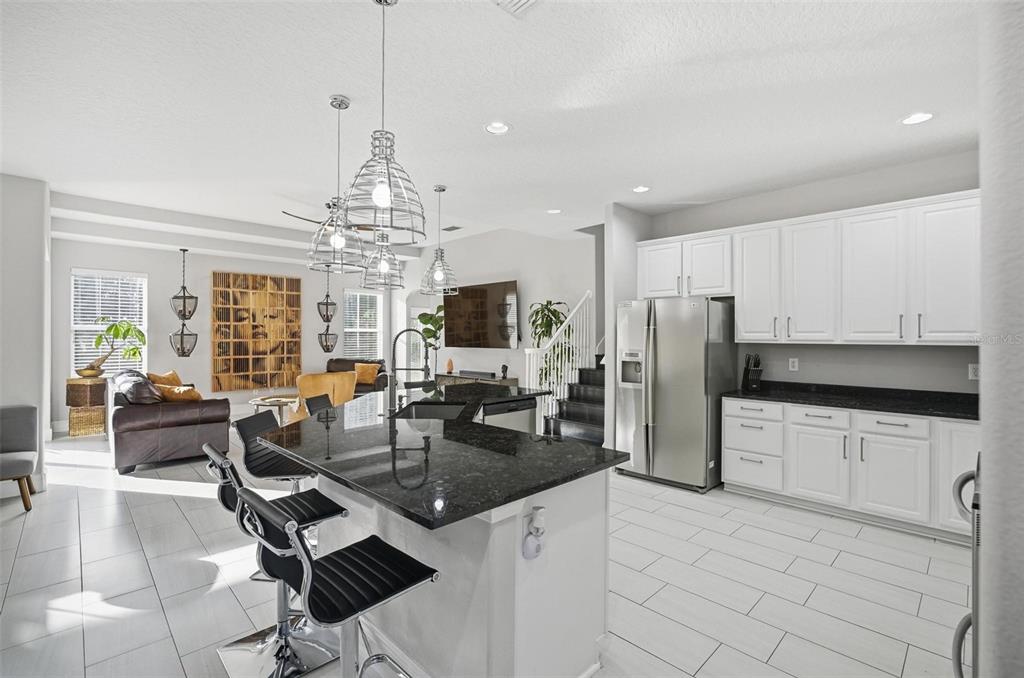 2914 Lee Shore Loop Orlando, FL 32820 - Photo 30 of 96 a kitchen with stainless steel appliances granite countertop a stove refrigerator a sink dishwasher with a dining table and chairs