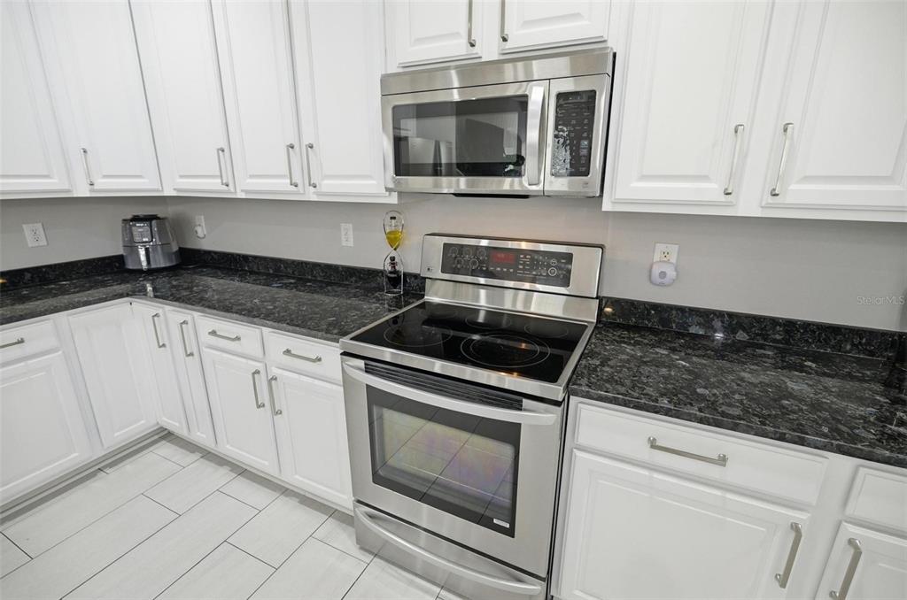 2914 Lee Shore Loop Orlando, FL 32820 - Photo 38 of 96 a kitchen with granite countertop white cabinets and stainless steel appliances