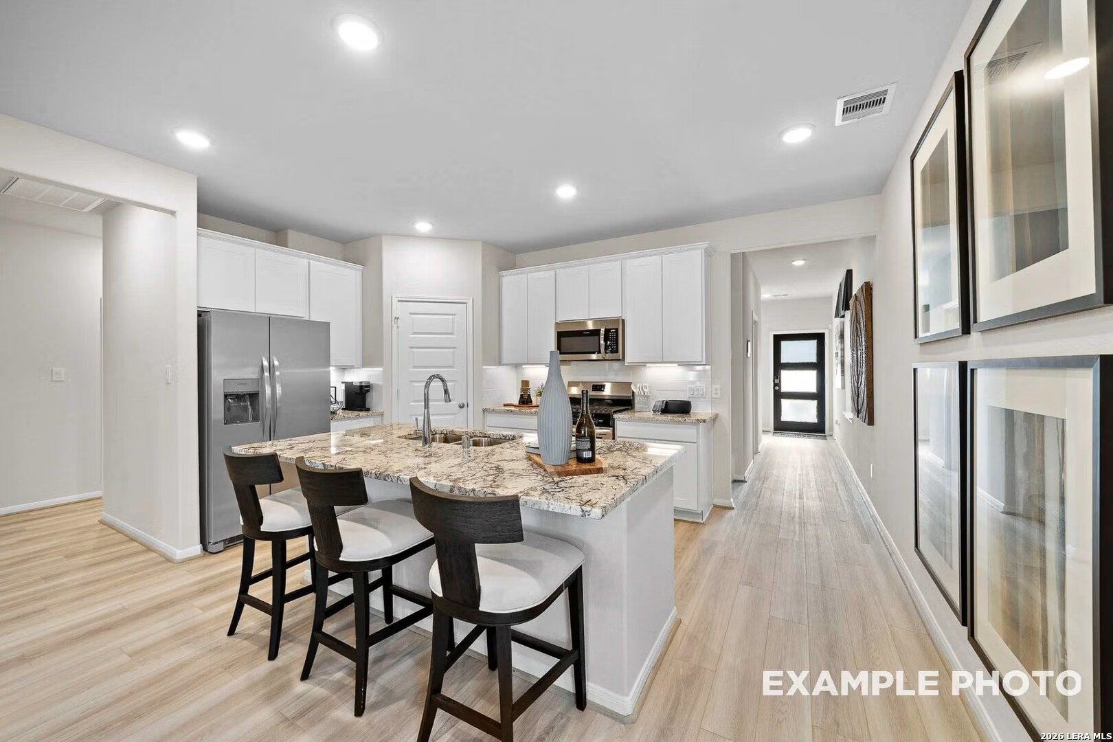 16611 Rosemary Ridge Elmendorf, TX 78112 - Photo 12 of 32 a kitchen with stainless steel appliances a dining table chairs refrigerator and microwave