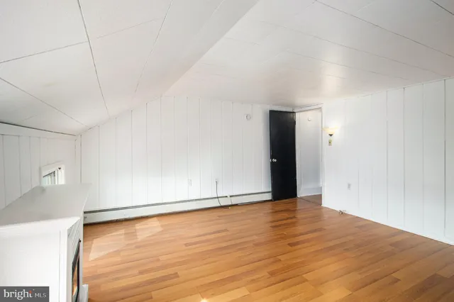 a view of an empty room with wooden floor