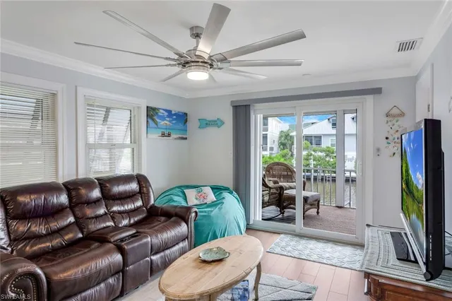 a living room with furniture a flat screen tv and a large window