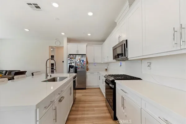 a kitchen with kitchen island a sink stainless steel appliances and cabinets