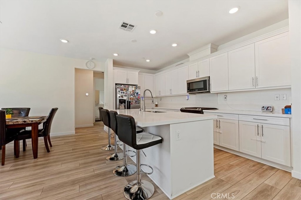 20911 Jennings Way Newhall, CA 91321 - Photo 12 of 50 a kitchen with a table chairs microwave and cabinets