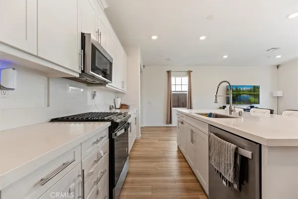 a kitchen with stainless steel appliances granite countertop a sink and stove top oven