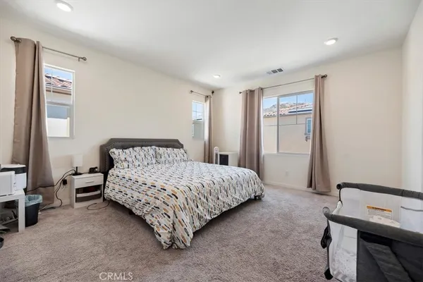 a spacious bedroom with a bed and a chandelier