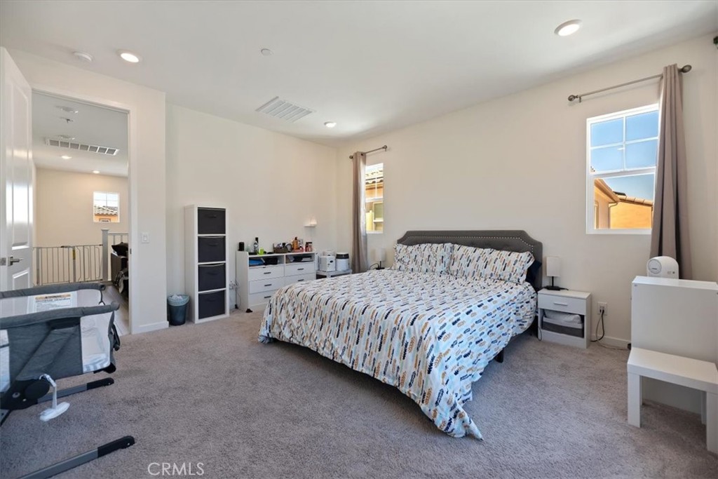 20911 Jennings Way Newhall, CA 91321 - Photo 36 of 50 a spacious bedroom with a bed and a chandelier