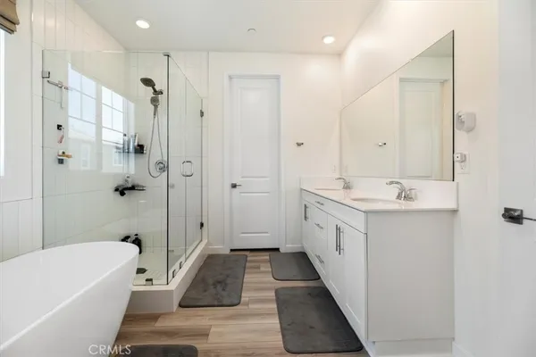 a bathroom with a tub shower and mirror