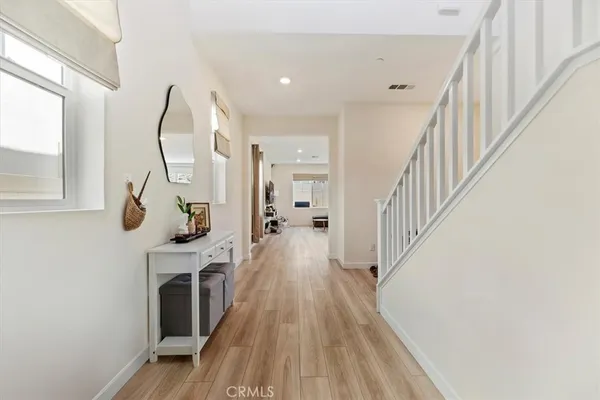 a view of a hallway with wooden floor fireplace and windows