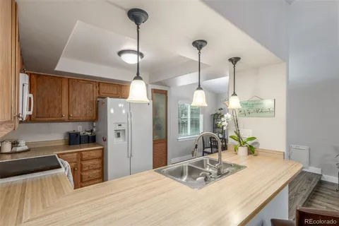 a kitchen with refrigerator cabinets and wooden floor