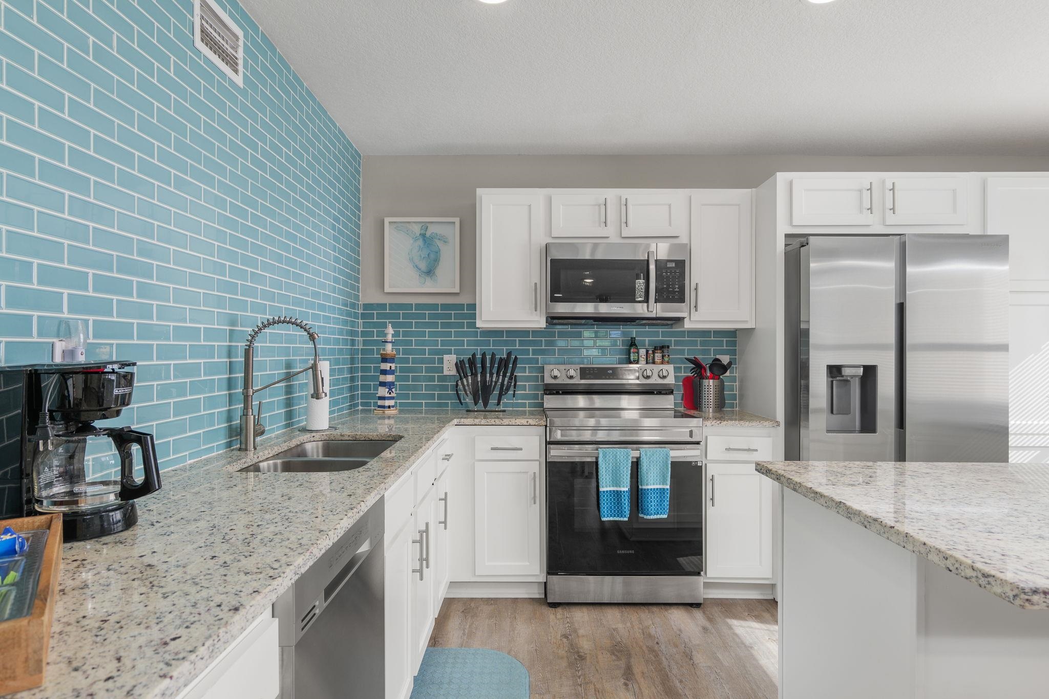 a kitchen with stainless steel appliances granite countertop a sink stove and refrigerator