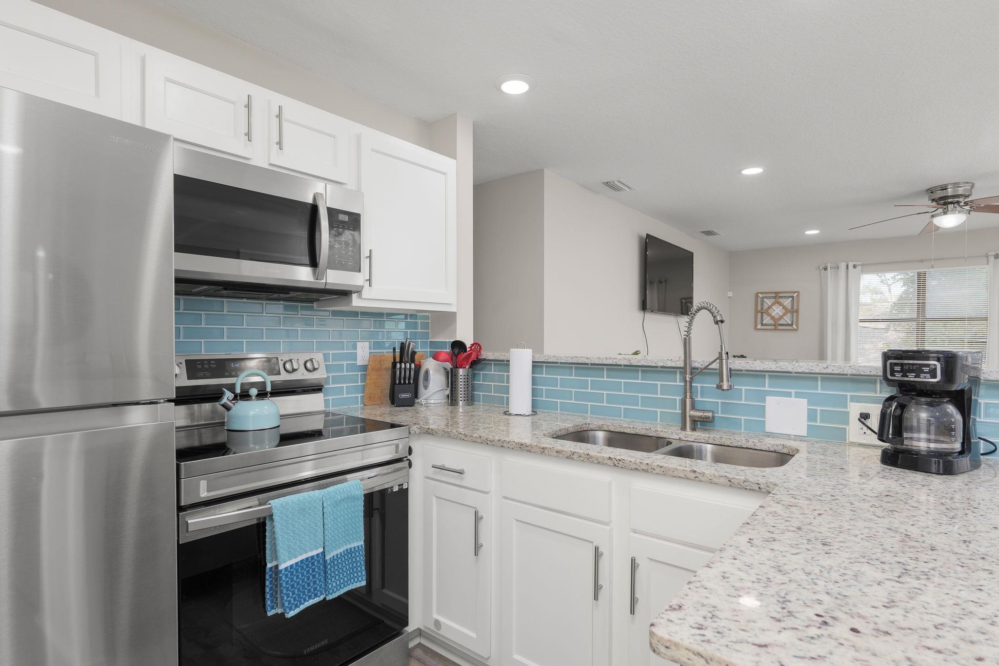 16 Ewing Street St. Augustine Beach, FL 32080 - Photo 19 of 55 a kitchen with stainless steel appliances granite countertop a sink stove and microwave
