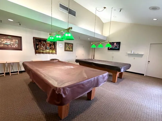 a room with pool table and windows