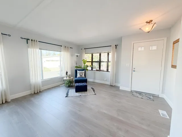 an empty room with chair and windows