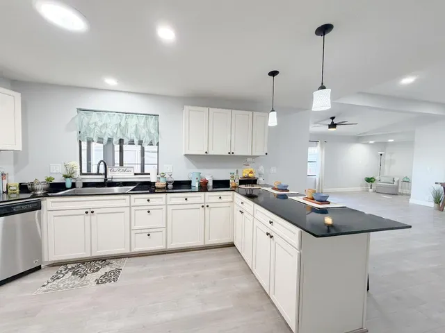a kitchen with granite countertop a sink a center island a counter space and a window