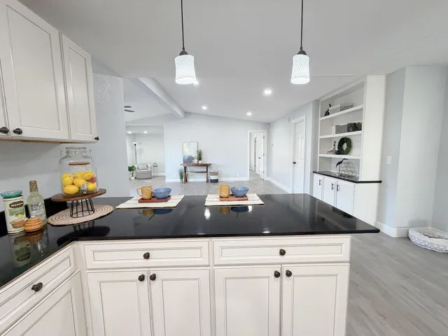 a kitchen with a white cabinets and chandelier