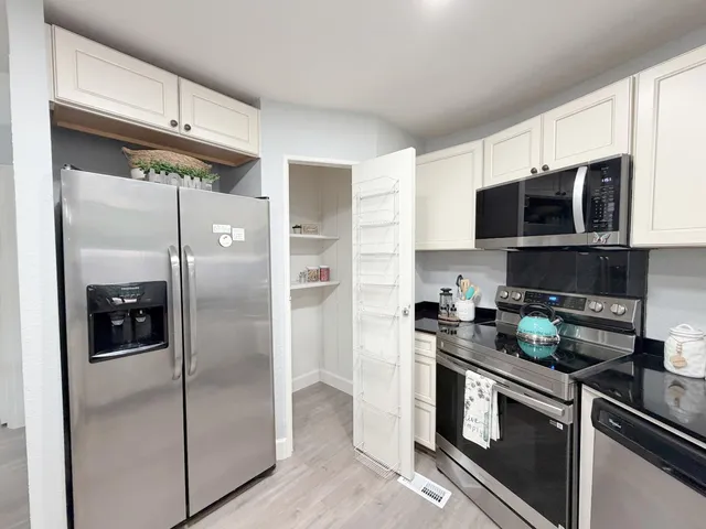 a kitchen with a refrigerator and a stove top oven