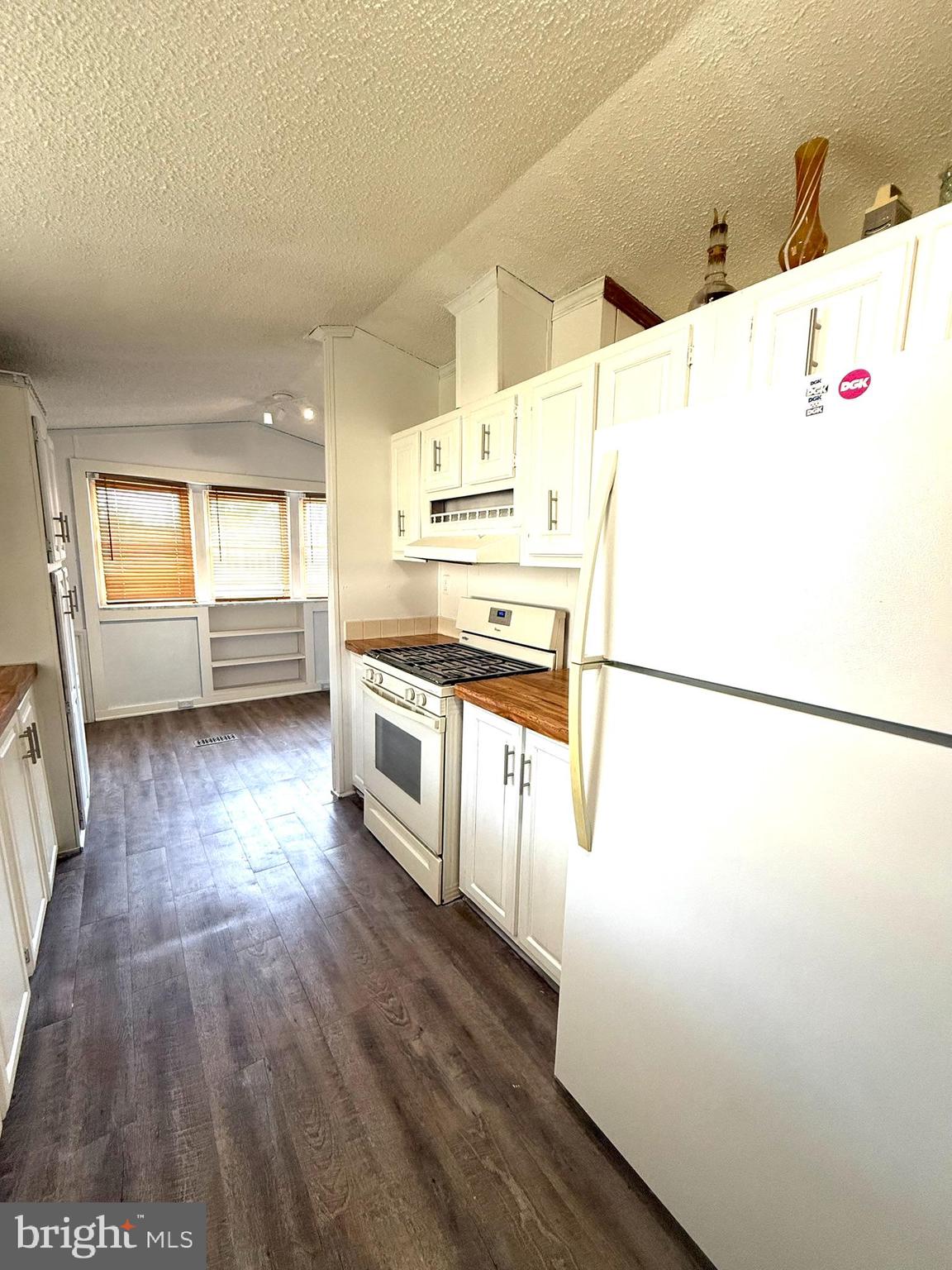2908 Ram Road Cambridge, MD 21613 - Photo 18 of 27 a kitchen with a refrigerator a stove top oven and a wooden floor