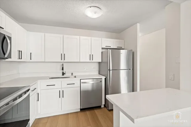 a kitchen with white cabinets and stainless steel appliances