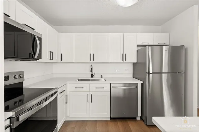 a kitchen with stainless steel appliances granite countertop a stove a sink and a refrigerator