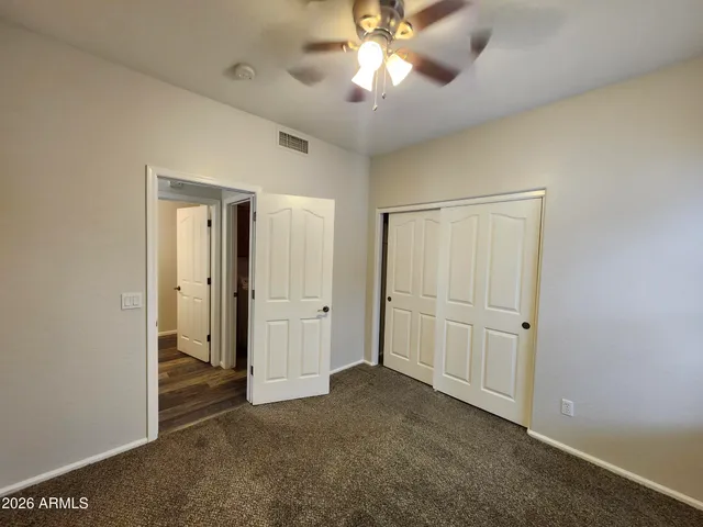 an empty room with windows and fan