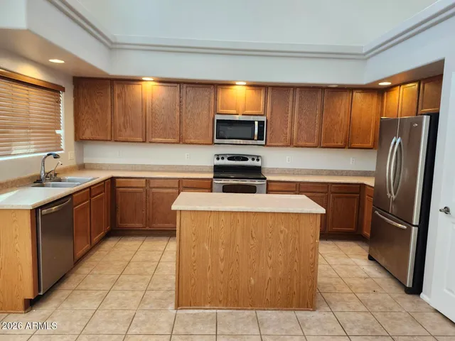 a kitchen with stainless steel appliances granite countertop a refrigerator and a stove top oven