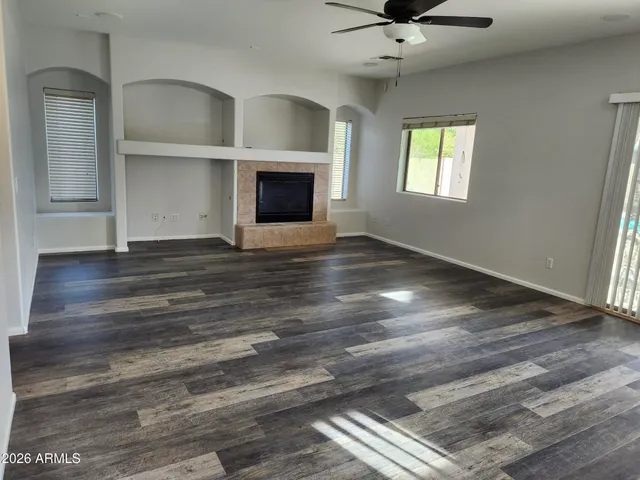 wooden floor fireplace and windows in an empty room