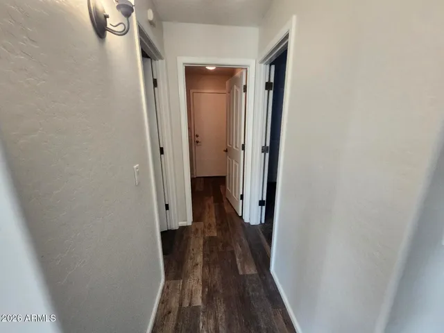 a view of a room with an entryway and chandelier fan