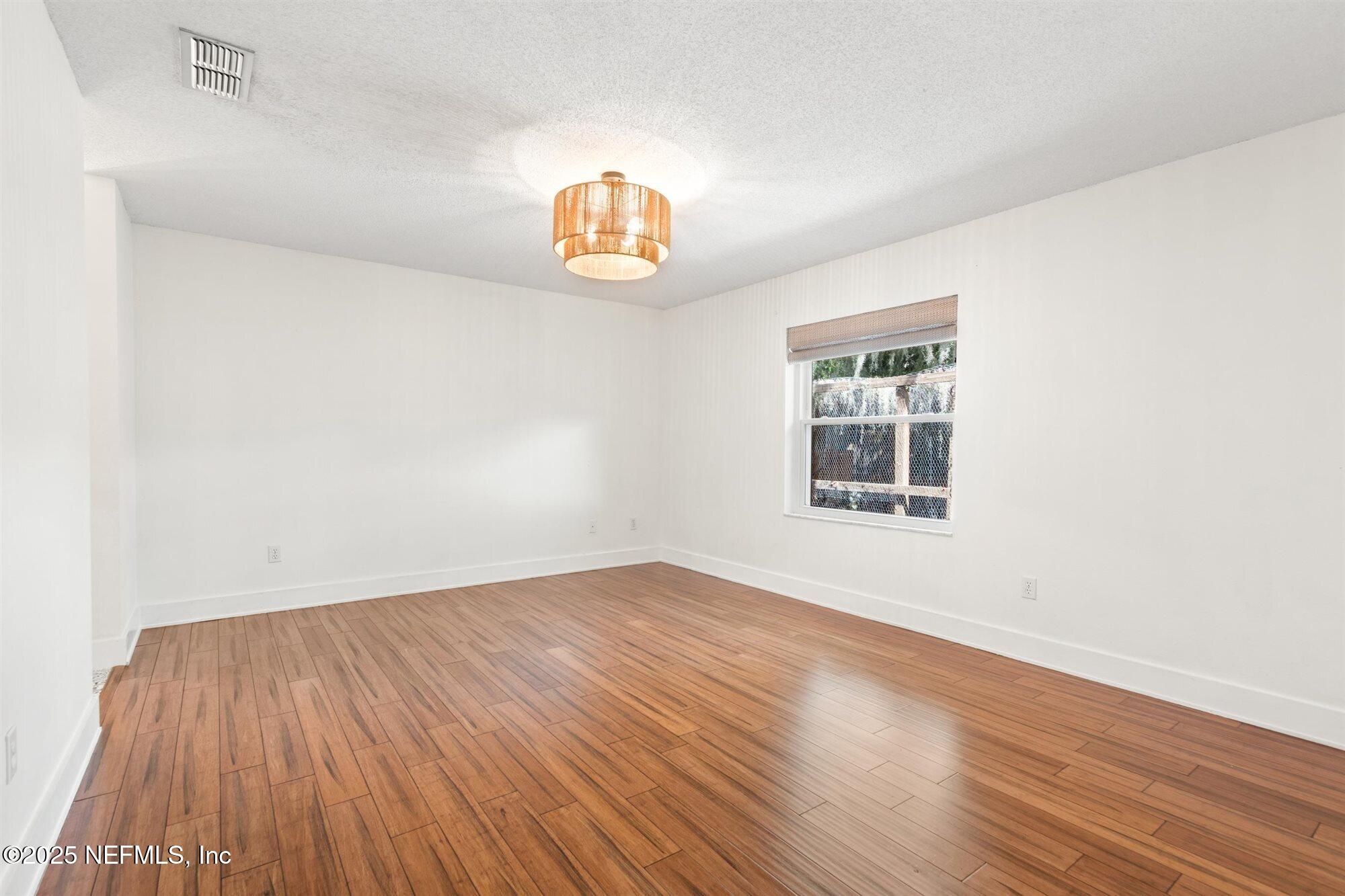 113 Mohegan Road St. Augustine, FL 32086 - Photo 18 of 56 an empty room with wooden floor and windows