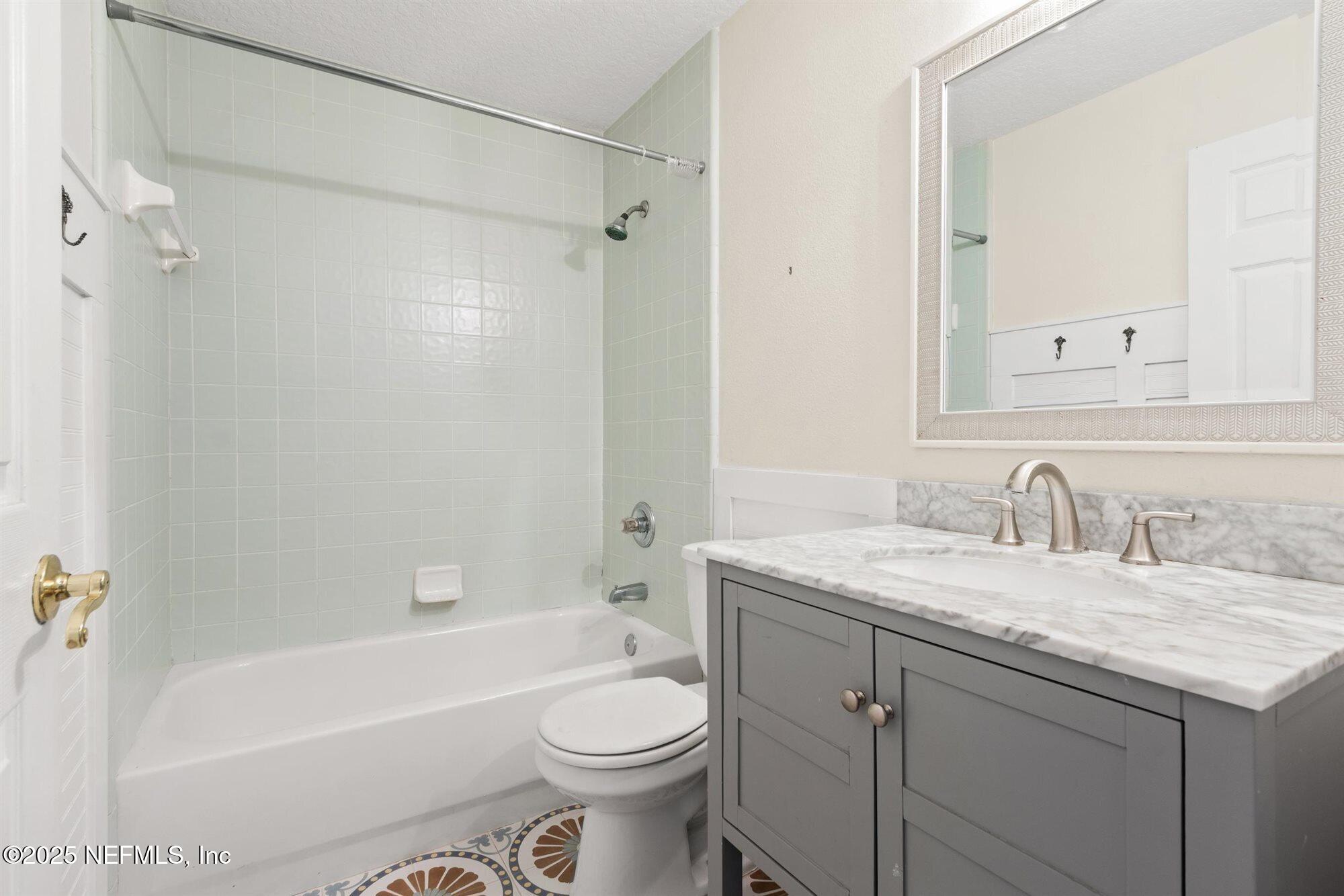 113 Mohegan Road St. Augustine, FL 32086 - Photo 27 of 56 a bathroom with a granite countertop sink toilet vanity mirror bathtub and shower