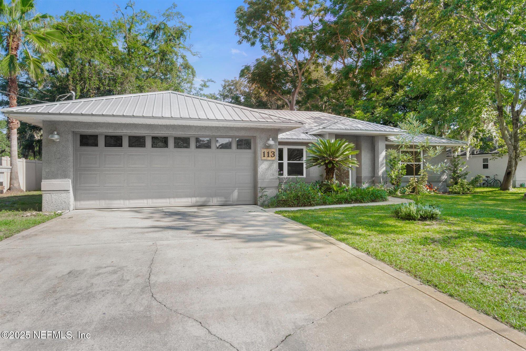 113 Mohegan Road St. Augustine, FL 32086 - Photo 4 of 56 a front view of a house with a garden