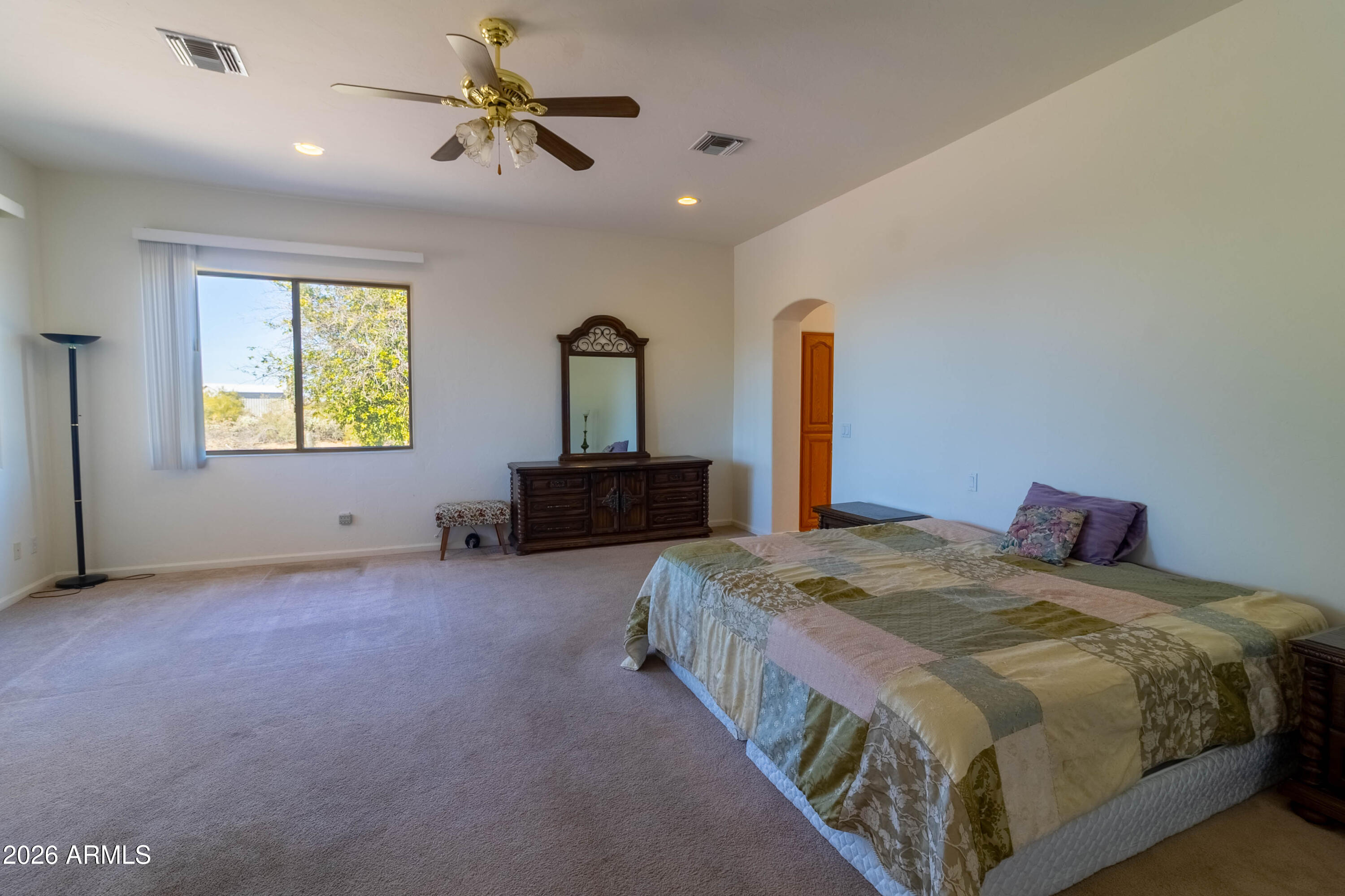 5159 North Lak A Yucca Road Tucson, AZ 85743 - Photo 25 of 66 a spacious bedroom with a bed and a chandelier