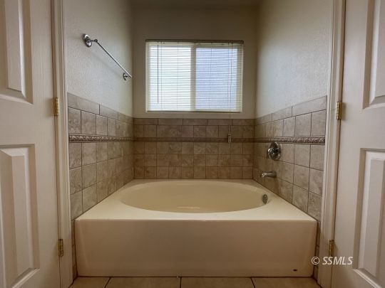 1133 West Benson Avenue Ridgecrest, CA 93555 - Photo 15 of 34 a white bath tub sitting in a bathroom next to a window