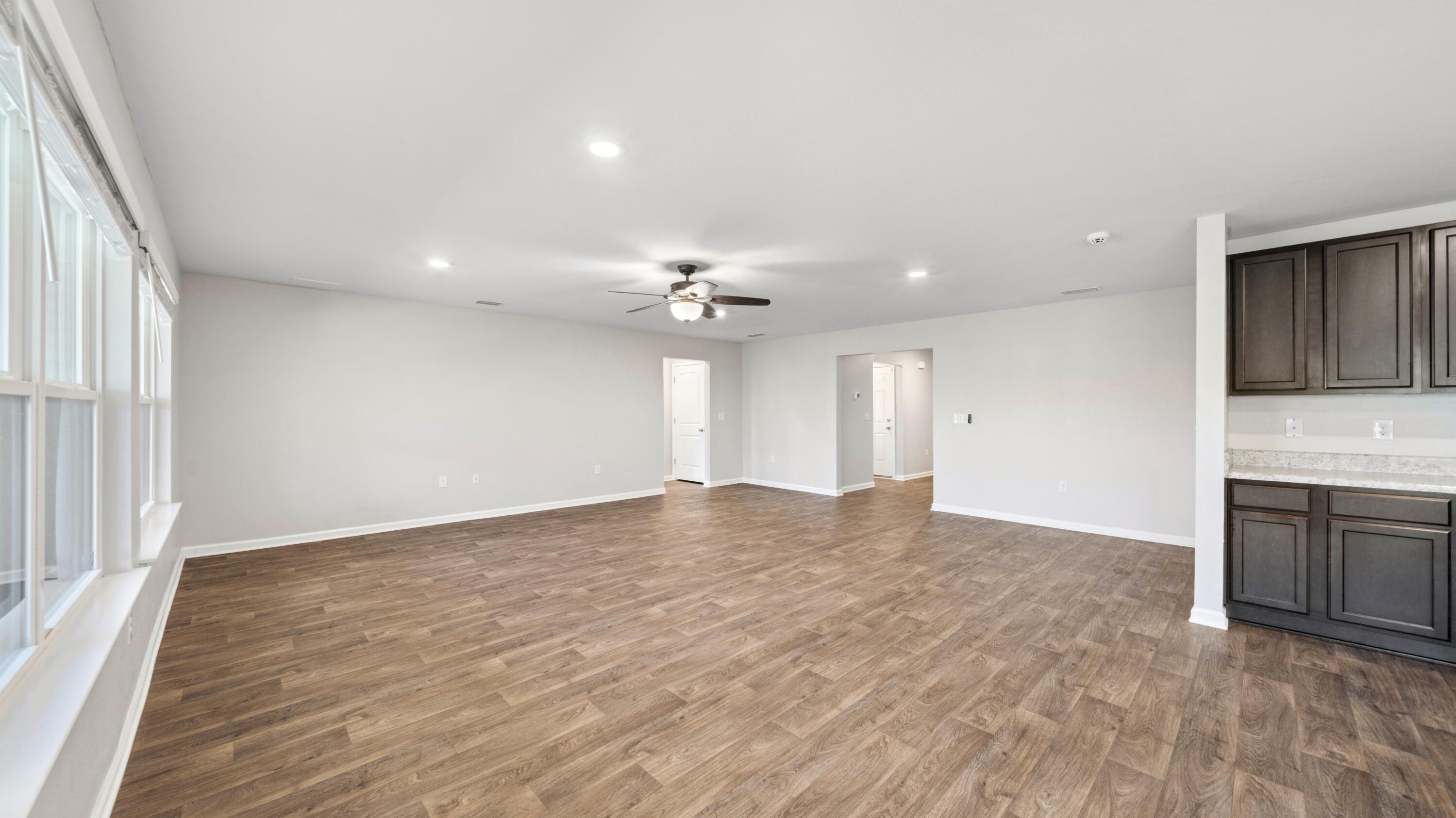 3927 Alva Thomas Road Panama City, FL 32404 - Photo 8 of 46 an empty room with chandelier fan and kitchen view