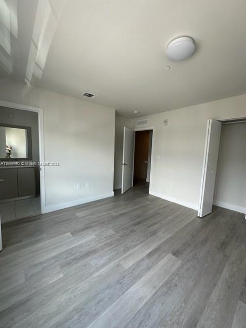 2561 Northeast 193rd Street, Unit 1207 Miami, FL 33180 - Photo 11 of 21 an empty room with wooden floor and cabinet