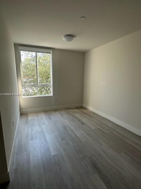 2561 Northeast 193rd Street, Unit 1207 Miami, FL 33180 - Photo 16 of 21 wooden floor in an empty room with a window