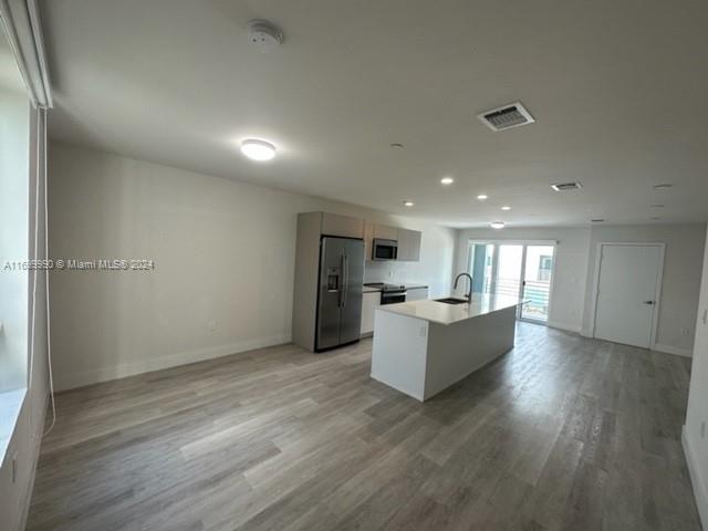 2561 Northeast 193rd Street, Unit 1207 Miami, FL 33180 - Photo 5 of 21 a living room with stainless steel appliances kitchen island hardwood floor and living room view