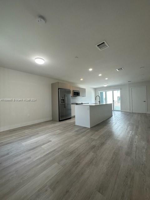 2561 Northeast 193rd Street, Unit 1207 Miami, FL 33180 - Photo 6 of 21 a view of empty room with wooden floor and kitchen