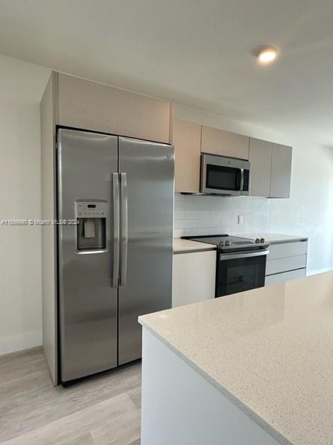 2561 Northeast 193rd Street, Unit 1207 Miami, FL 33180 - Photo 8 of 21 a kitchen with stainless steel appliances a refrigerator and a stove top oven
